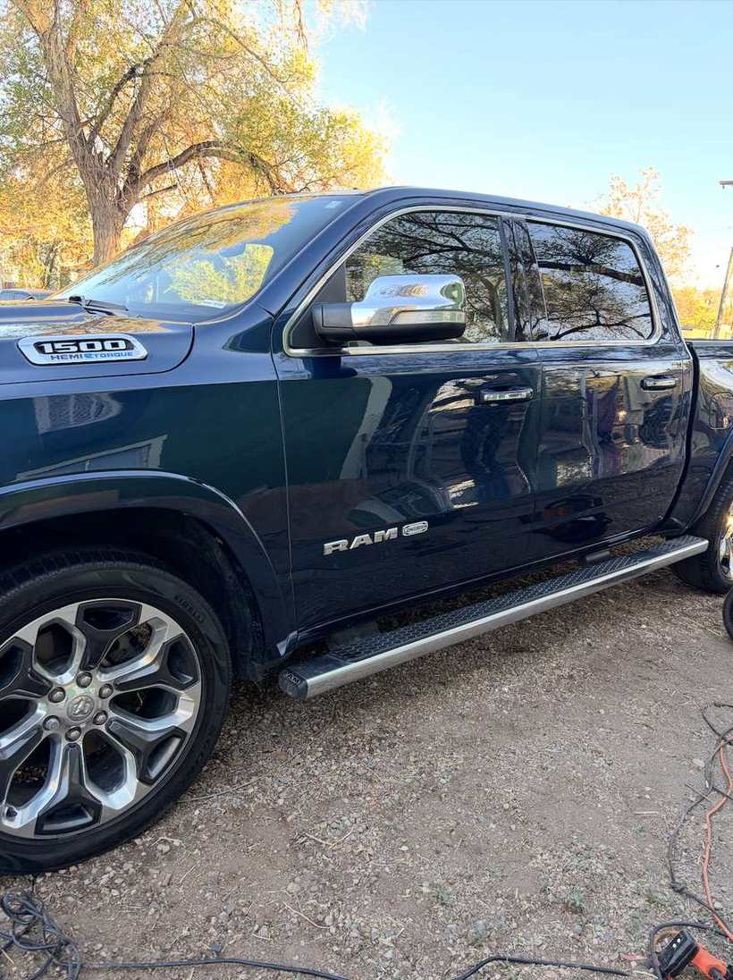 After — the same pickup washed, paint glossy and reflecting the trees